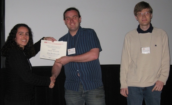 Evelyn Sander gives prizes to John Wordsworth (middle) and Christian Kuehn (right) at the DSWeb Student Competition awards ceremony at the SIAM Conference on Applied Dynamical Systems in Snowbird, Utah, May, 2007; photo by Hinke Osinga.